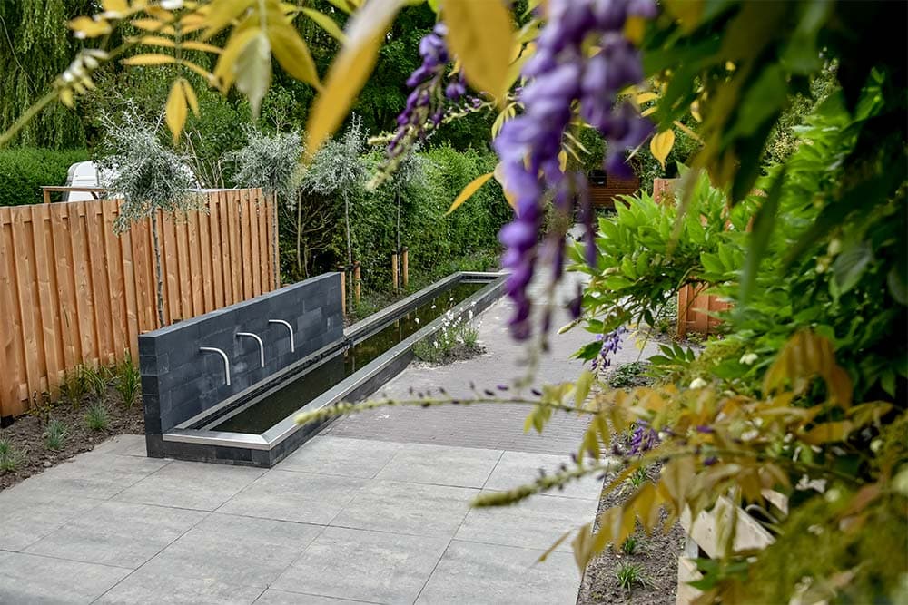 Lange smalle tuin met een kleine moderne vijver