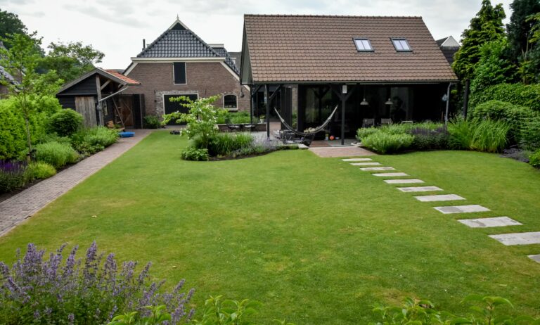 Landelijke strakke tuin met tuinhuis en paadje.